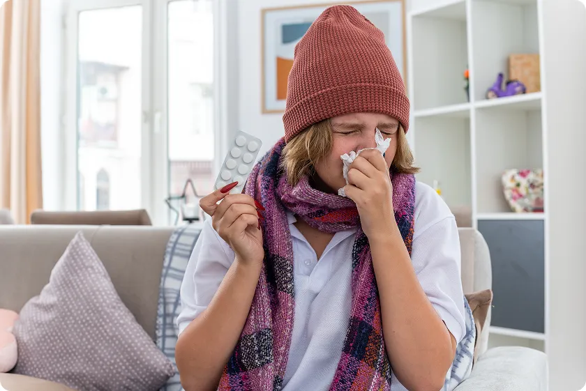 Individual sneezing with tissue due to winter allergies night discomfort.