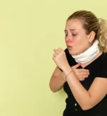 2 Woman coughing and covering throat due to allergy attack and throat allergy symptoms