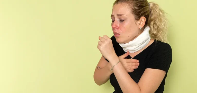 Woman coughing and covering throat due to allergy attack and throat allergy symptoms
