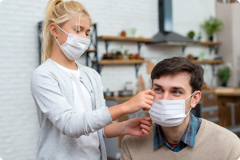 Young girl helps her father wear a face mask minimizing nasal polyps symptoms.