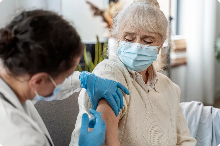 Senior woman receives flu vaccines for seniors during routine clinic visit