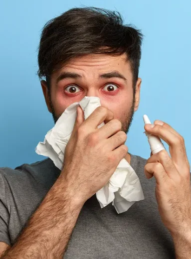 2 Man using nasal spray for relief from dust allergy and dust mite symptoms.