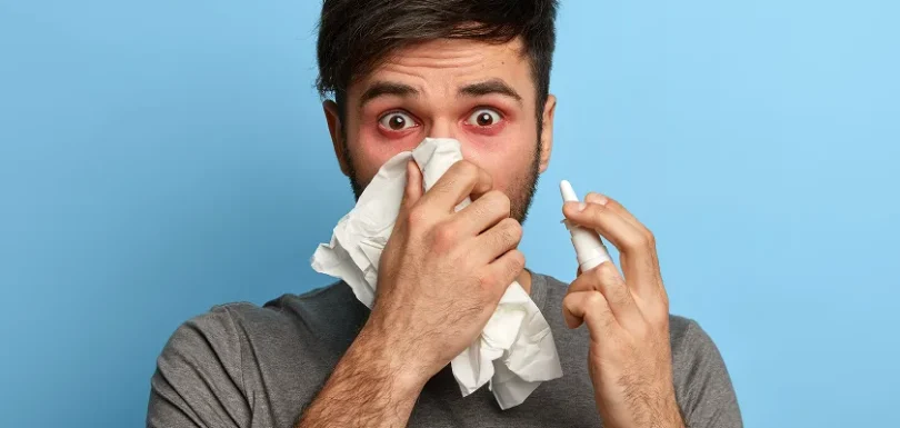Man using nasal spray for relief from dust allergy and dust mite symptoms.