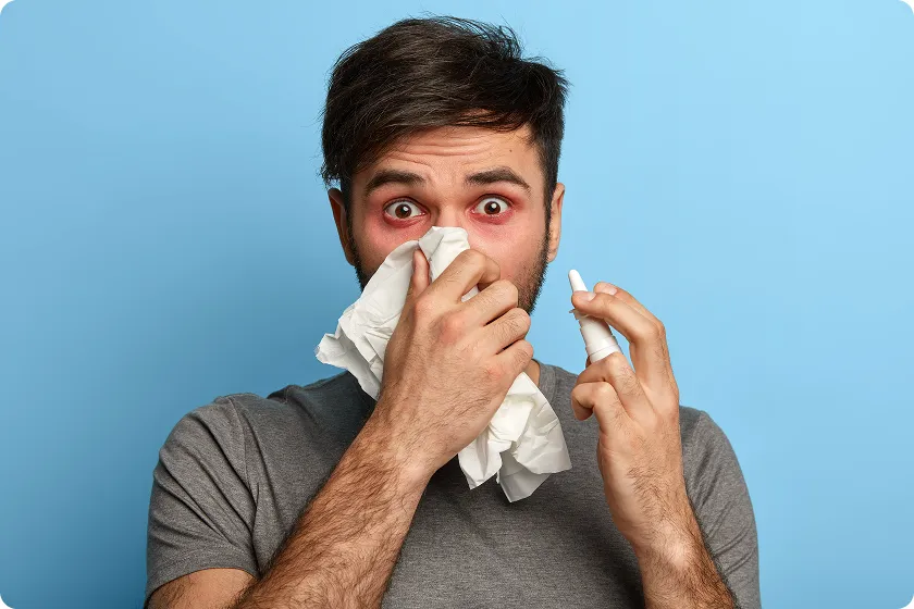 Man using nasal spray for relief from dust allergy and dust mite symptoms.