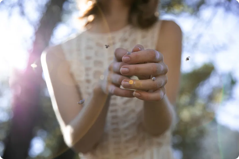 Woman handling insects outdoors showing ant allergy symptoms, awareness of yellow jacket allergy.