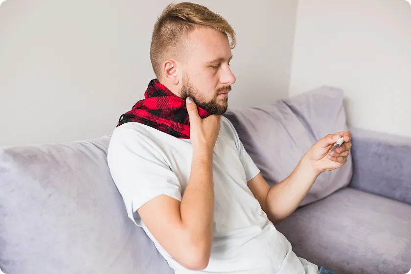 Person checking temperature with throat allergy symptoms during allergy attack at home
