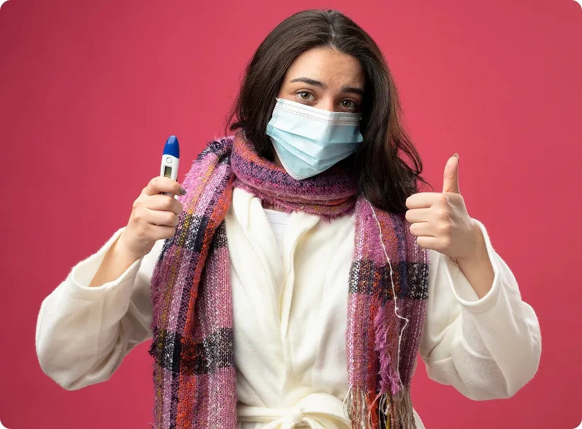 Masked woman checks temperature after high dose flu vaccine recovery