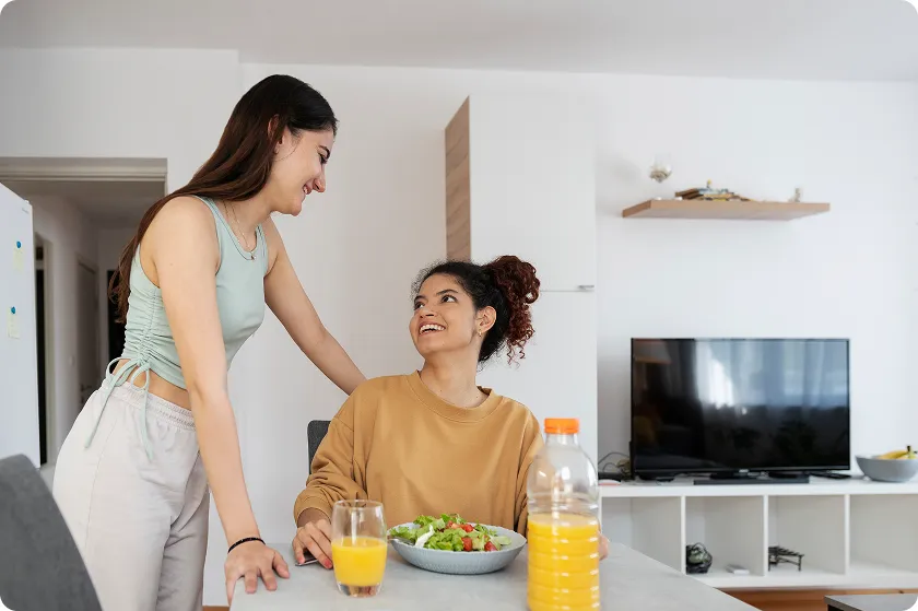 Two healthy women eating a nutritious salad to support innate and adaptive immunity.