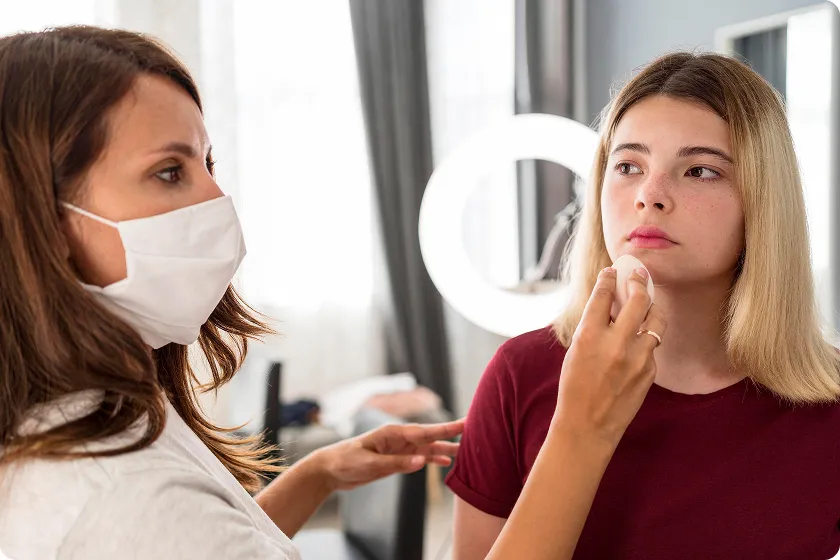Masked specialist examines a young woman's nose discovering what are nasal polyps.