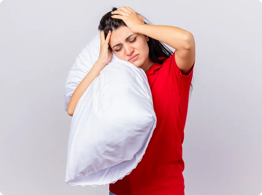 Woman holding pillow with headache from dust allergy skin rash.