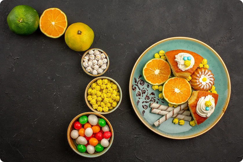 Assorted sweets, pastries, and citrus slices illustrating sugary foods to avoid diverticulosis.