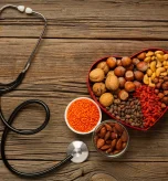Heart failure diet foods with nuts, lentils, and a stethoscope.