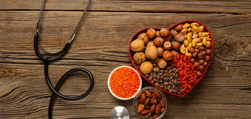 Heart failure diet foods with nuts, lentils, and a stethoscope.