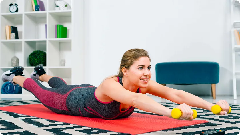 Woman performs weighted floor exercises in a weight loss training plan.