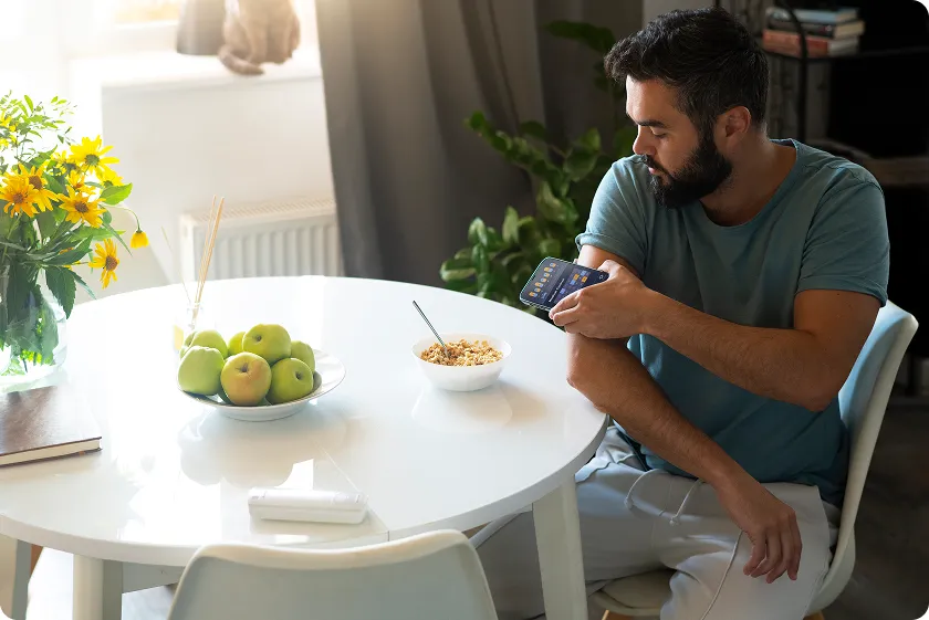 A man using glucose monitor showing signs of diabetes fatigue concerns