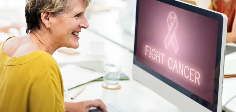 Older woman uses online resources to advocate for yourself during cancer care.