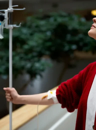 Seated patient receiving NAD+ IV drips under NAD+ infusion safety monitoring