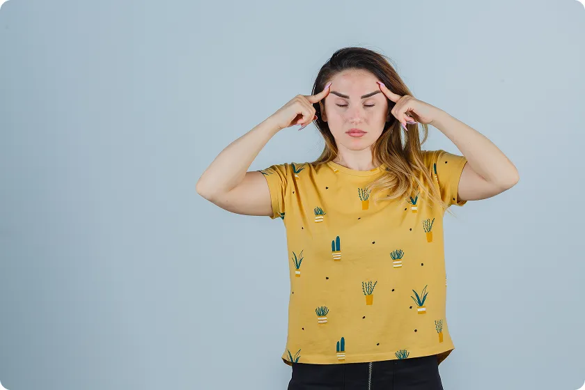 Woman presses temples while experiencing migraine aura and related migraine myths.