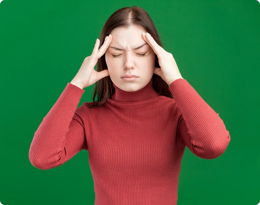 Young woman holds temples, challenging migraine myths and migraine misconceptions.