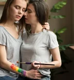 A couple embracing while painting, reflecting LGBTQIA+ anxiety and minority stress together.
