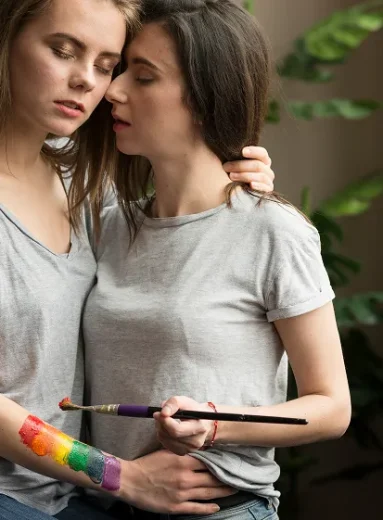 A couple embracing while painting, reflecting LGBTQIA+ anxiety and minority stress together.