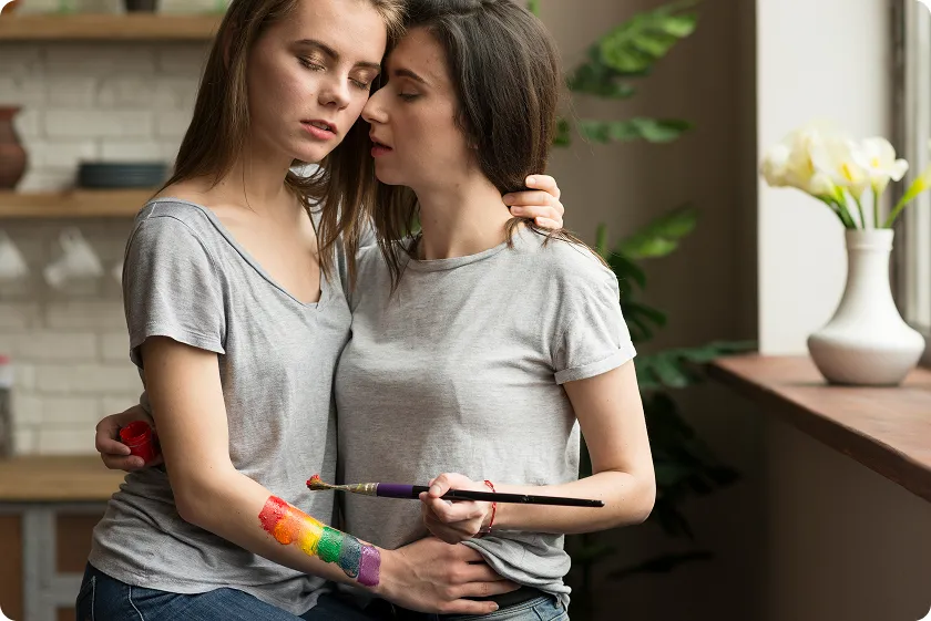 A couple embracing while painting, reflecting LGBTQIA+ anxiety and minority stress together.
