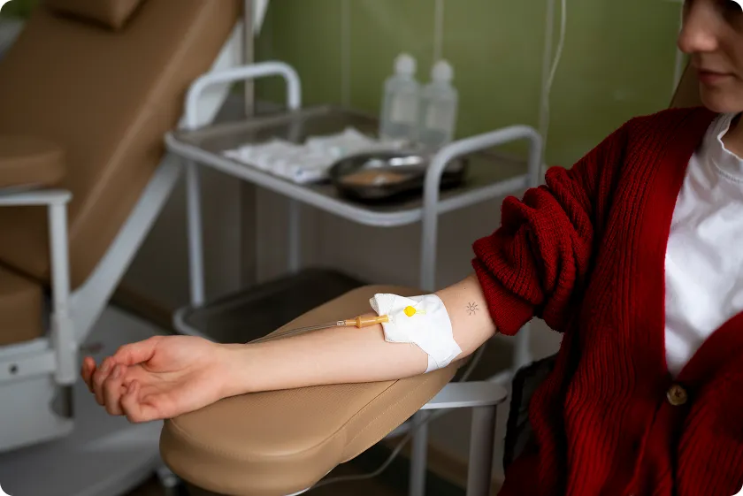 Masked patient holding NAD+ IV drips during NAD+ infusion safety checks