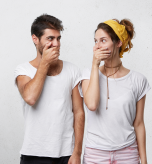 1 Man and woman laughing while covering mouths, explaining why like the smell of own farts