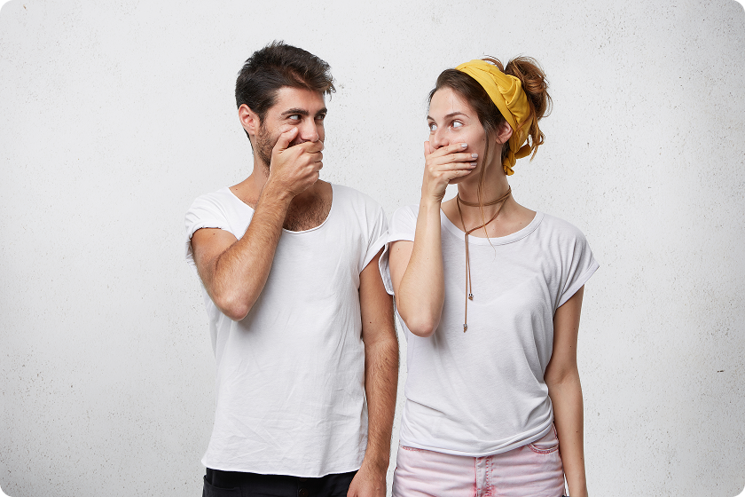 Man and woman laughing while covering mouths, explaining why like the smell of own farts