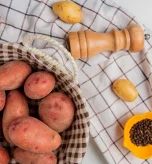 Fresh raw potatoes arranged in a basket for preparing sweet potato gerd recipes.