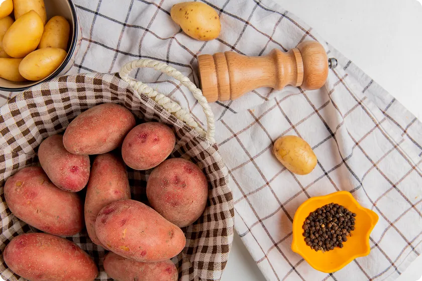 Fresh raw potatoes arranged in a basket for preparing sweet potato gerd recipes.