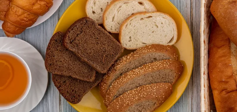 Yellow plate filled with various baked goods illustrating typical carbs in bread options.